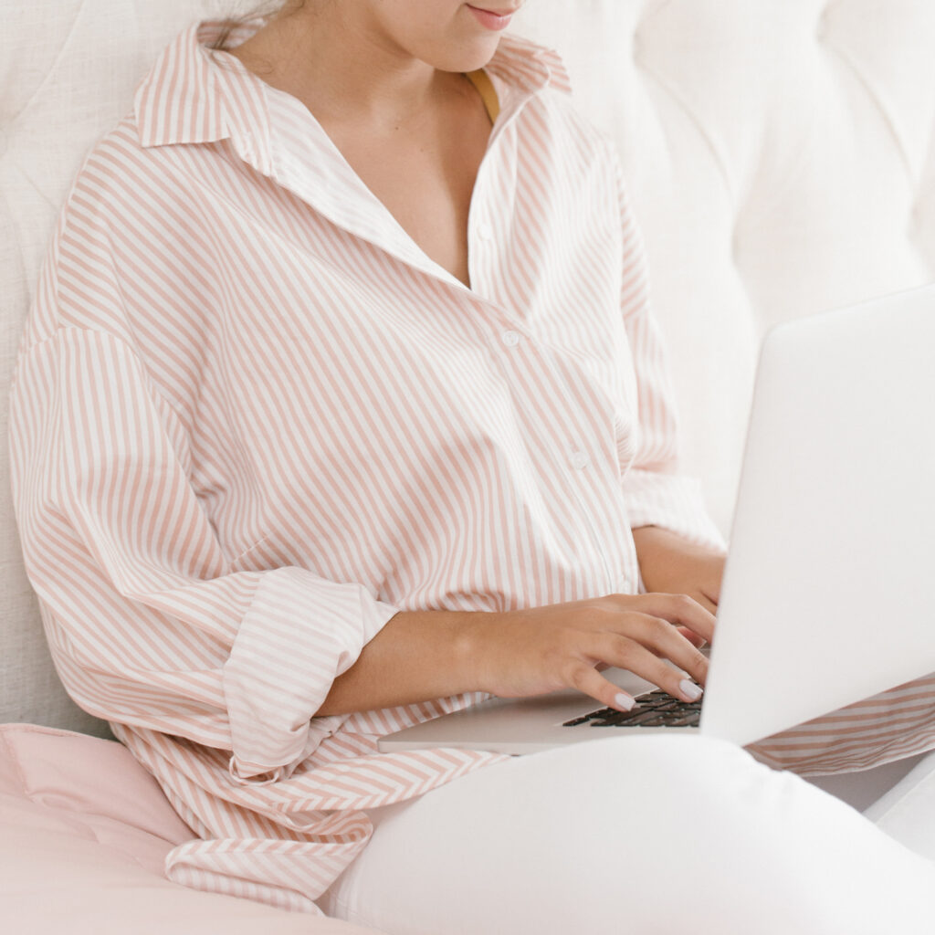 woman in pink blogging on her laptop