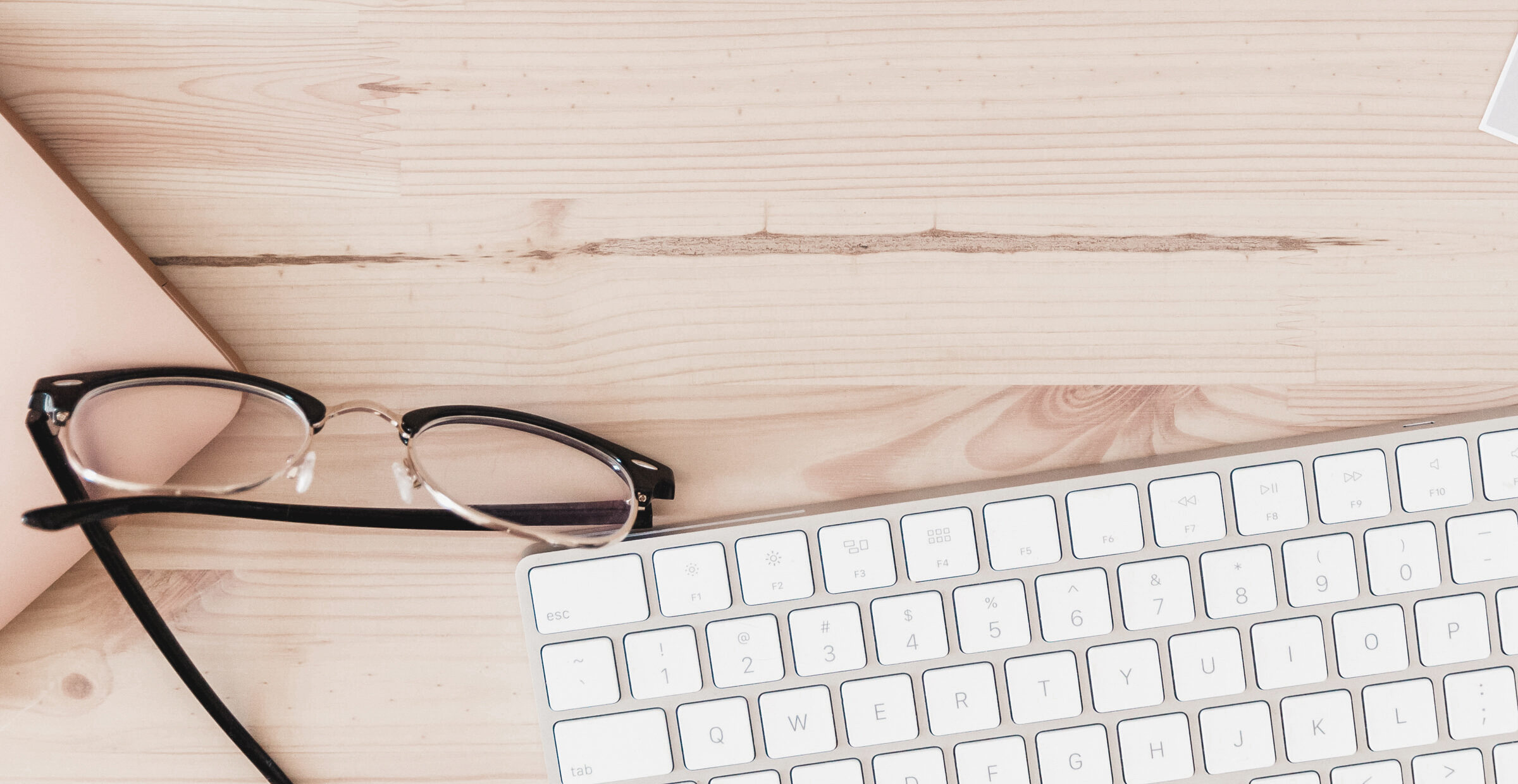 the essential tools for blogging: keyboard, laptop, glasses, coffee and notebook