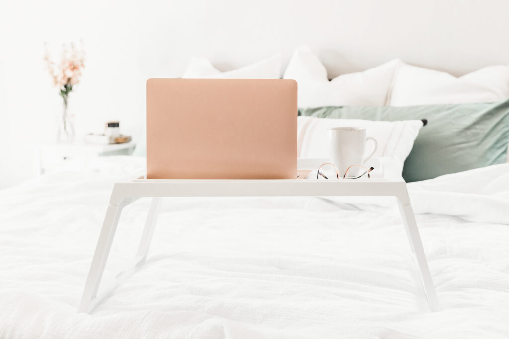 laptop on bed desk for blogging