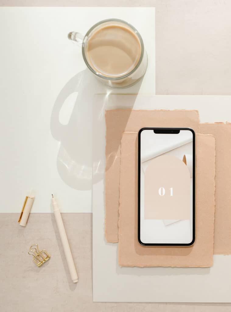 blogging essentials like a phone, a pen, and a cup of coffee